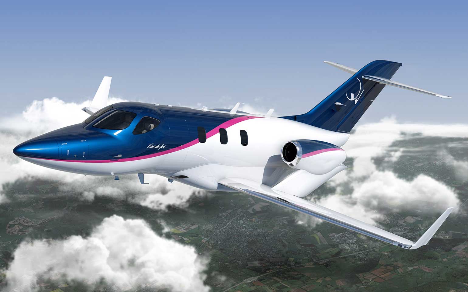 HondaJet aircraft flying in clouds with fields below