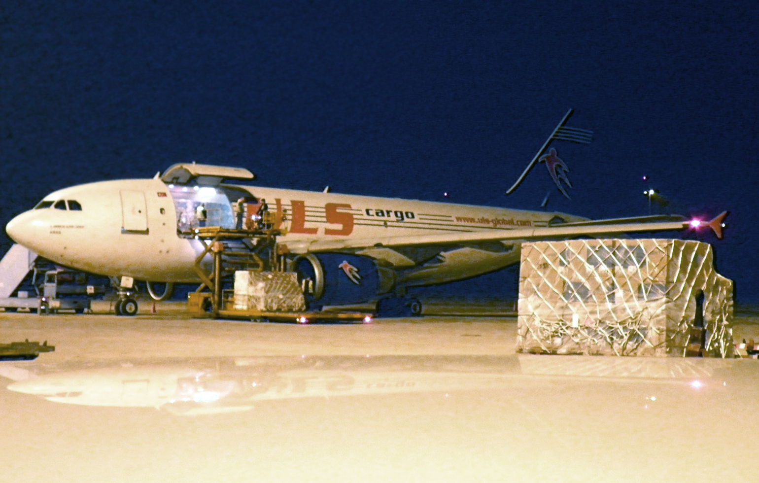Airbus A310F cargo charter aircraft with freight on runway at night