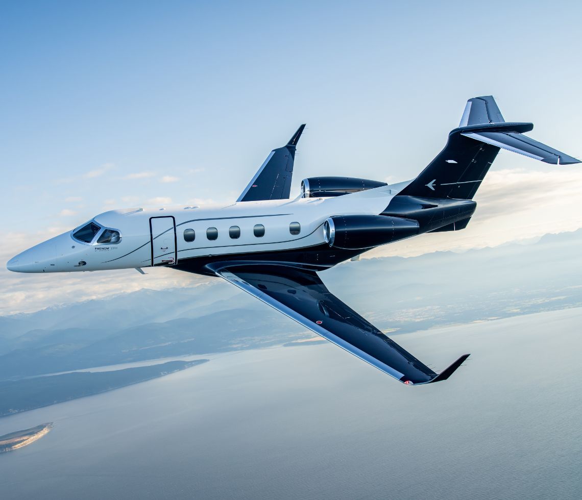 Embraer Phenom 300E flying above lake