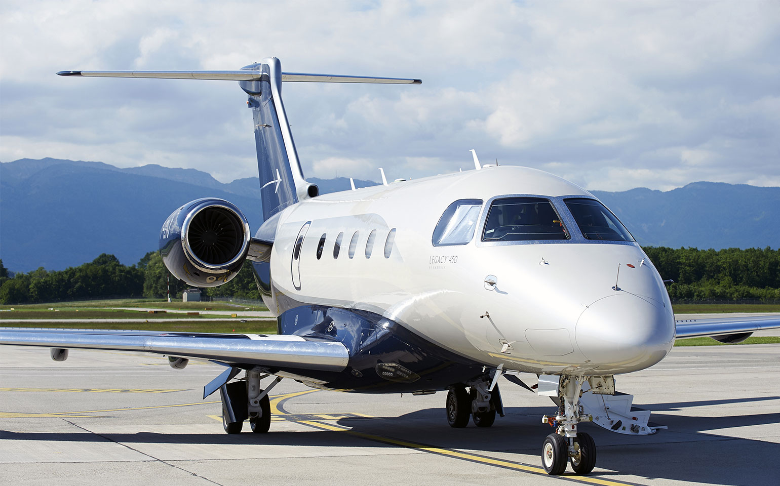 Embraer Legacy 450 private jet charter on runway during day